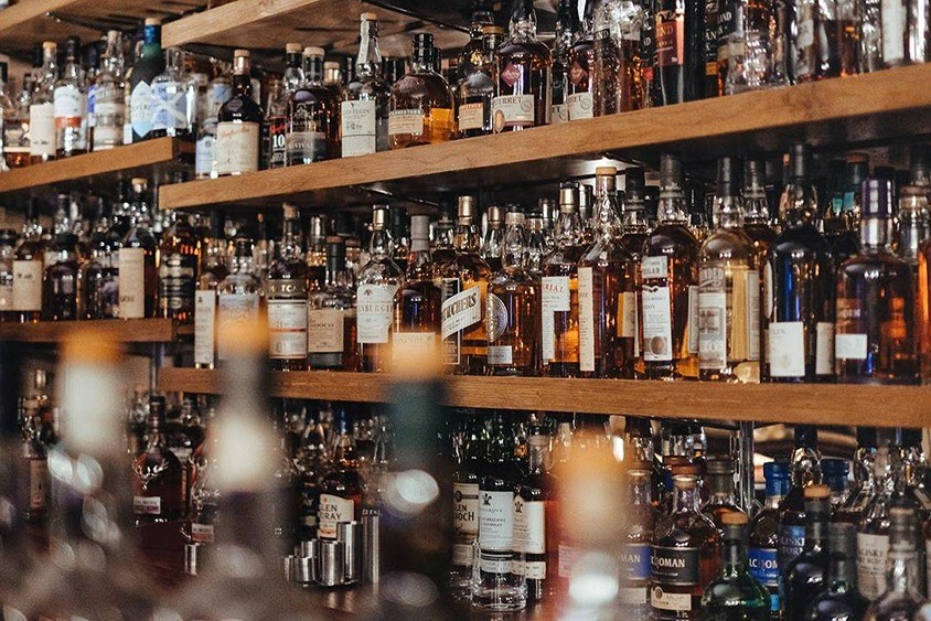 Police plná alkoholických nápojů.